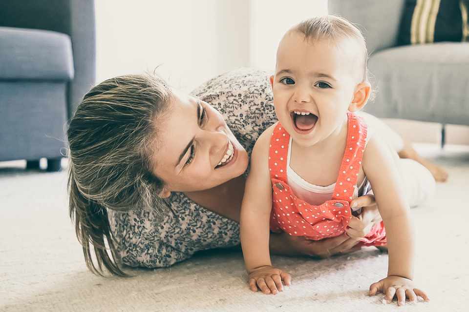 mother and child playing on white carpet